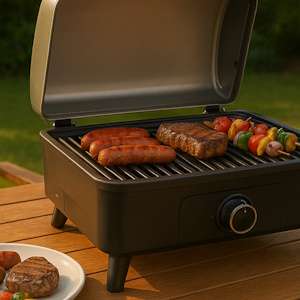 Tischgrill mit Grillgut im Garten